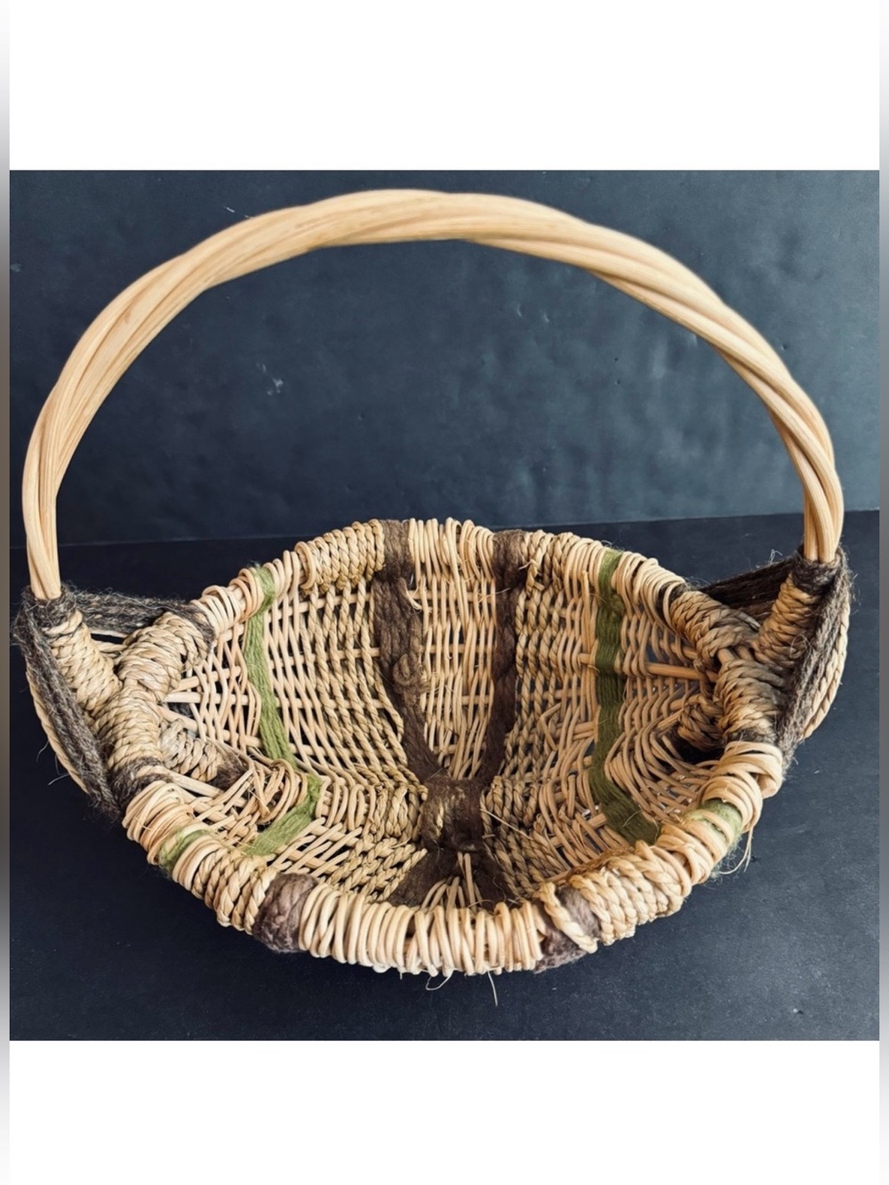 Vintage handwoven basket with brown and green yarn details and eye of God.